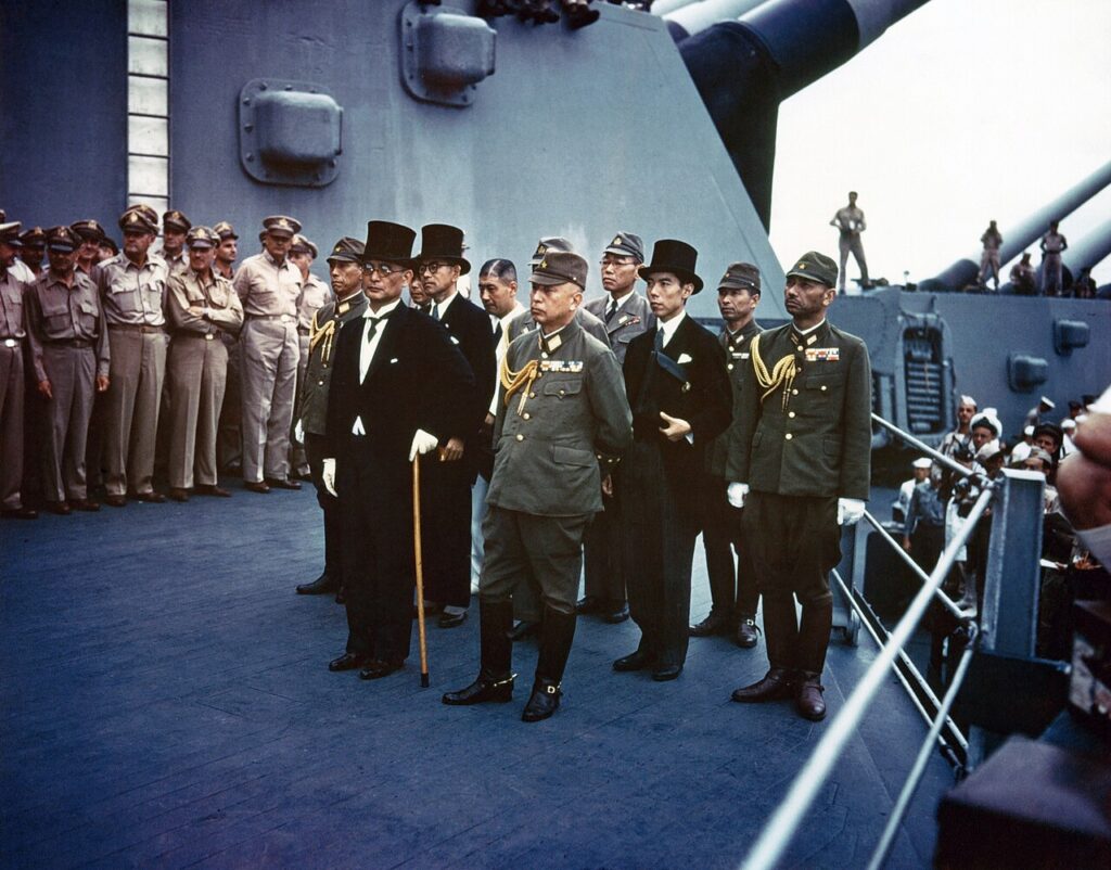 A colour photograph. Japanese representatives on board USS Missouri (BB-63) during the surrender ceremonies, 2 September 1945.