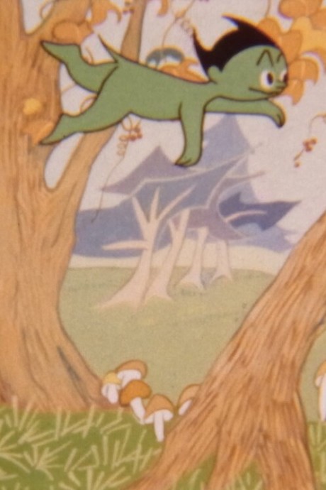 A colour animated still. Over a forest background, a green humanoid fly-swims across the screen. It has black hair with two spiky points on each end.
